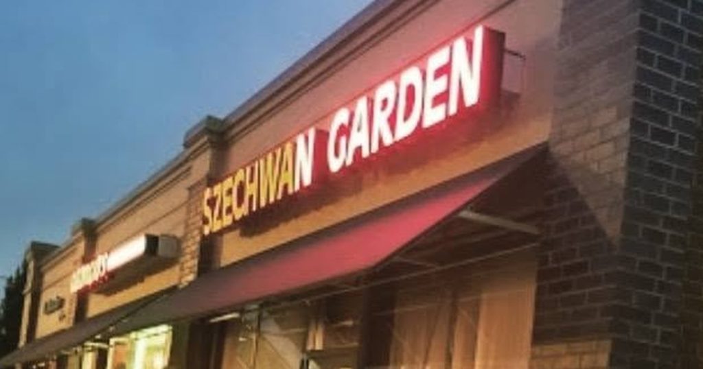 The lit Szechwan Garden sign above a red awning on a brick storefront on Detroit Avenue at dusk